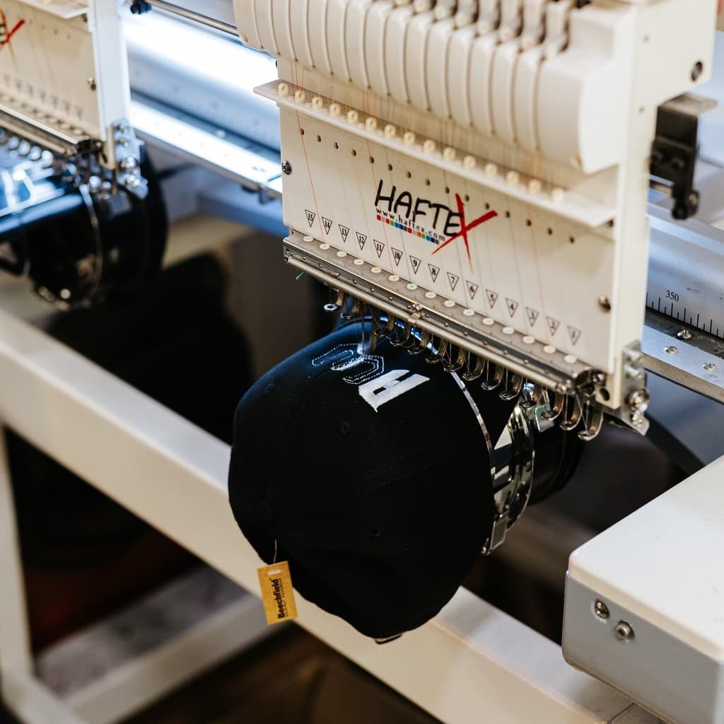 Haftek multi-needle embroidery machine creating custom designs on band merchandise