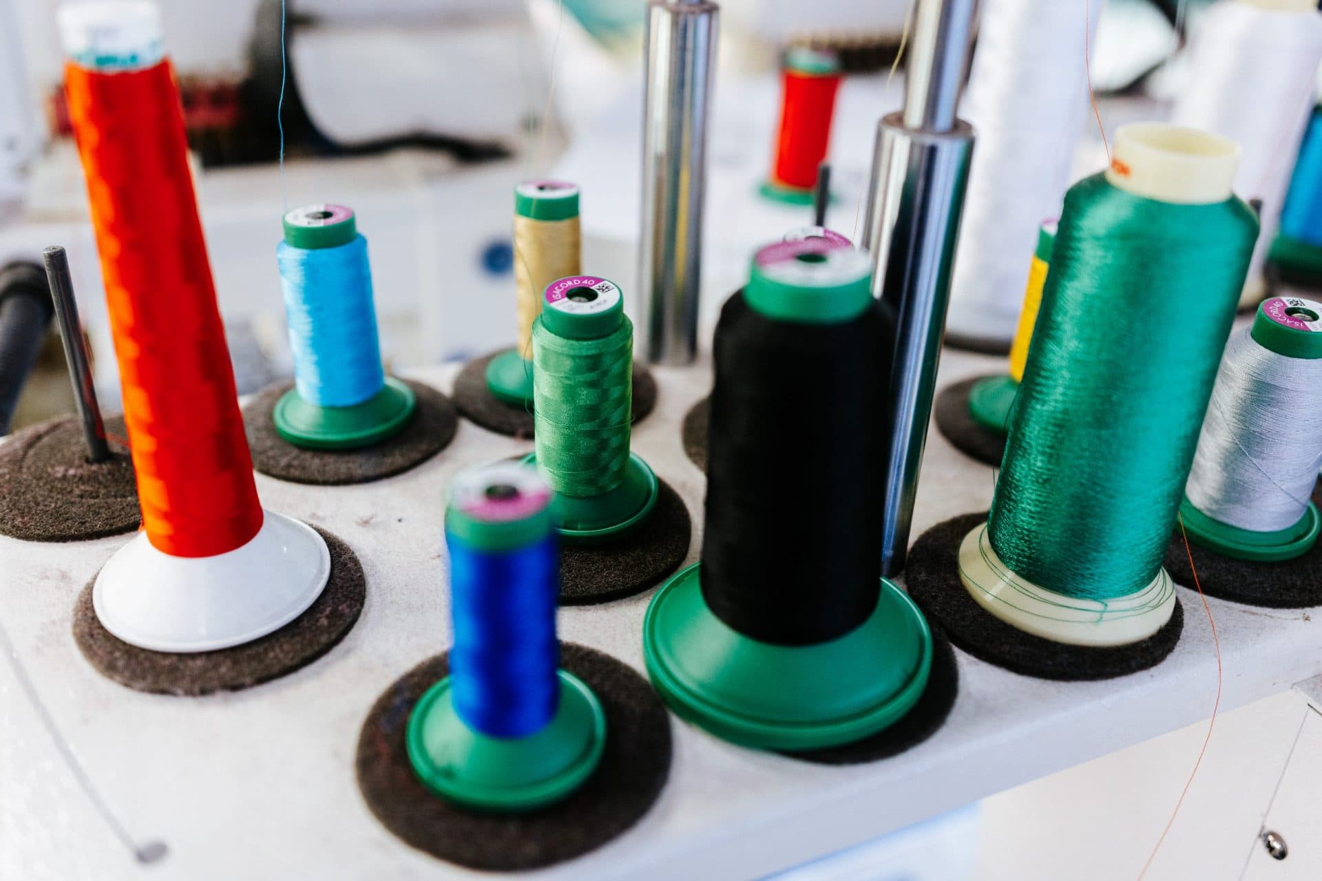 Colorful embroidery thread spools ready for multi-color custom merchandise production