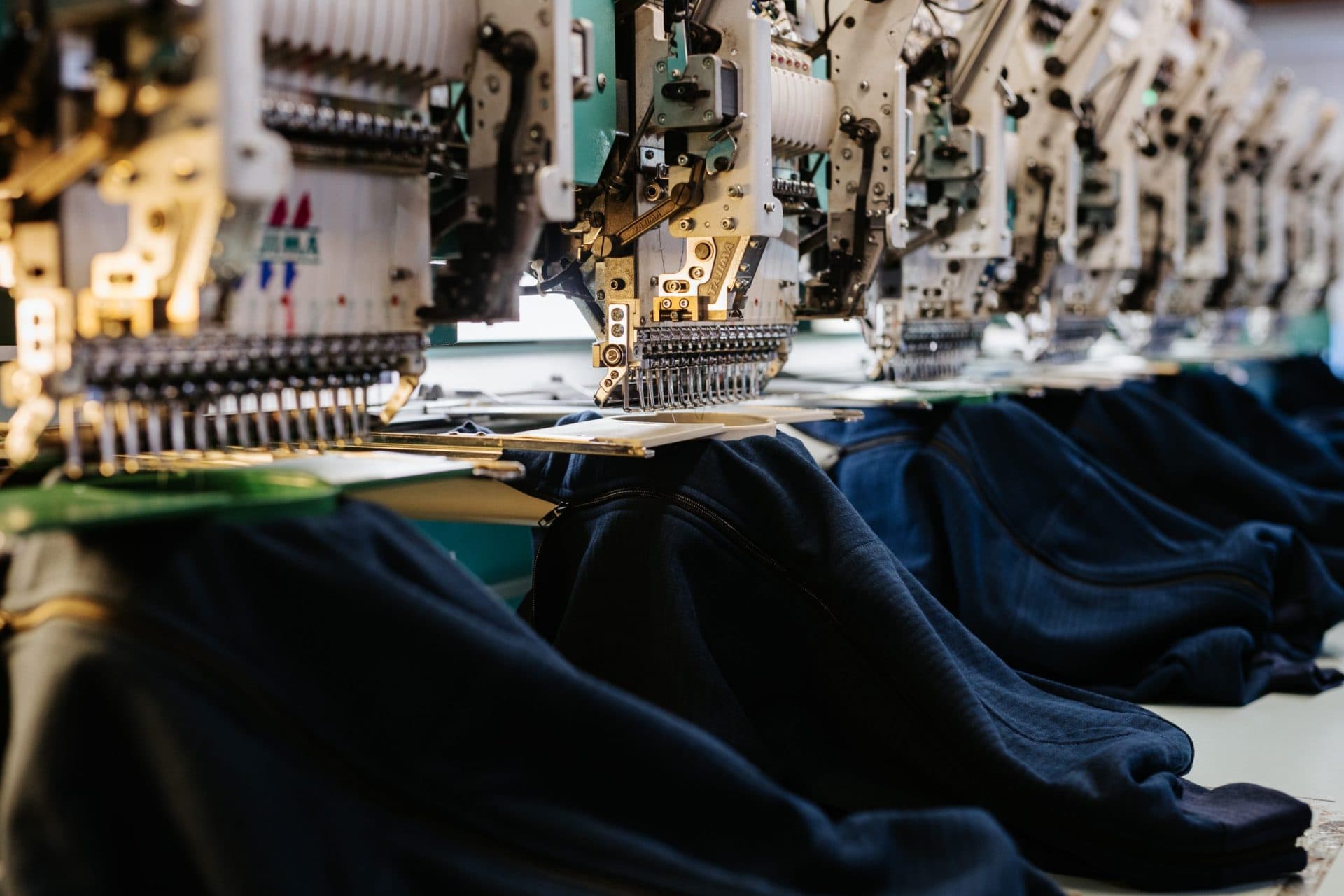 Professional multi-head Haftek embroidery machine creating custom band merchandise designs