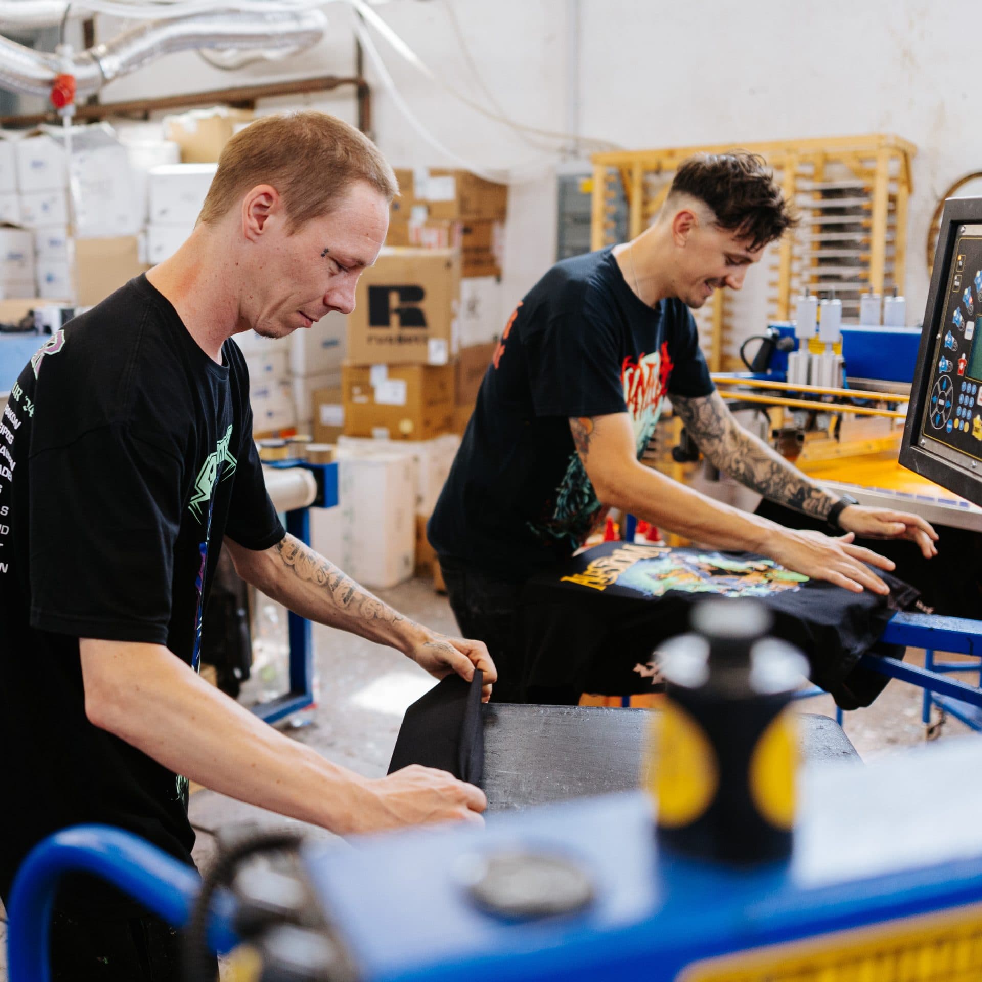Screen printing professionals creating custom band merchandise at Real Pimp Budapest workshop